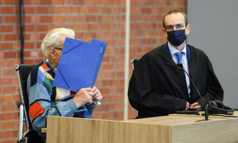The accused, Josef S (left), covers his face in the court room in Brandenburg.