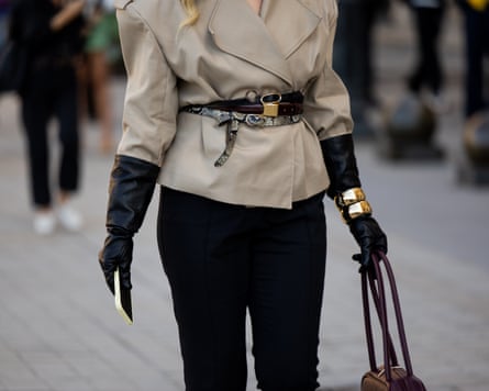 A guest wears grey belted jacket, black leather gloves, bracelets, pants with slit, burgundy bag outside Louis Vuitton during the womenswear Spring Summer 2026 as part of Paris fashion week on 30 September 2025.
