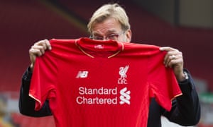 Liverpool’s new manager Jürgen Klopp hides his face with a shirt as he poses for pictures after being appointed the club’s new manager on a three-year deal.