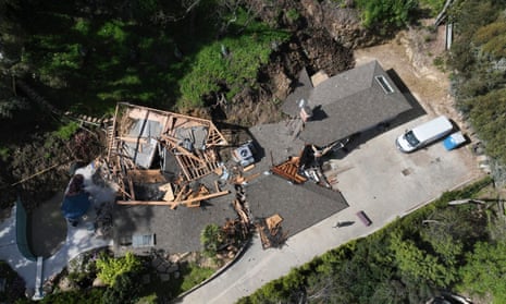 Aerial view of home with gray roof pulled off in one section.