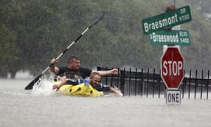 Two kayakers try to beat the current pushing them down an overflowing Brays Bayou.