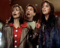 Courteney Cox, Jamie Kennedy and Neve Campbell stand bloodied, staring upward in shock in 'Scream'
