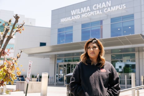 A young woman stands outside a hospital.