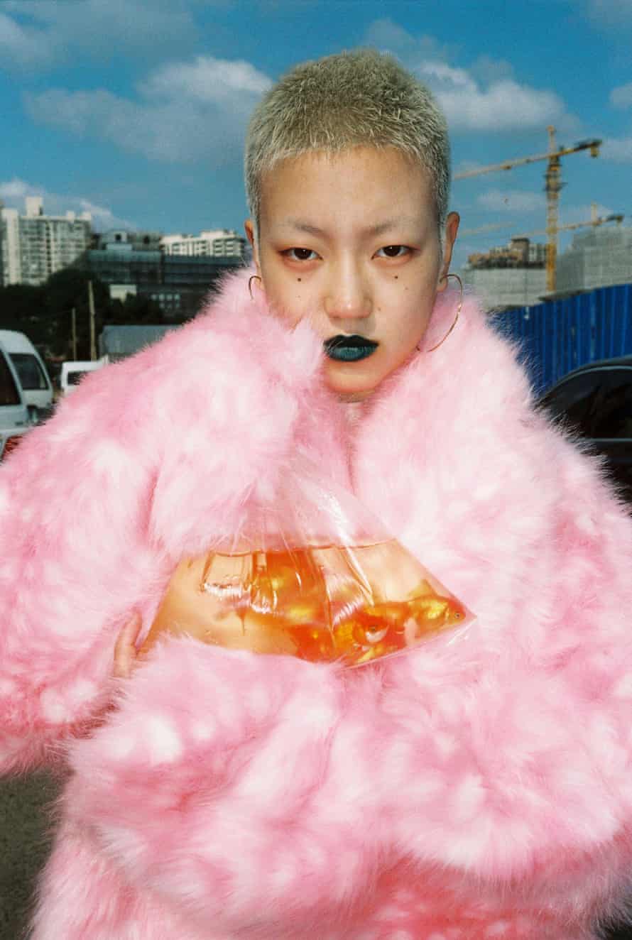 Portrait of a woman holding a goldfish in a bag