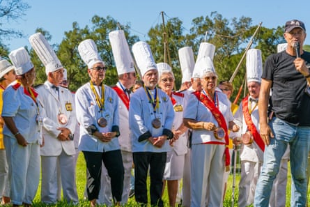 The chefs line up in their white uniforms, to be greeted by Kanak traditional owners to the park.