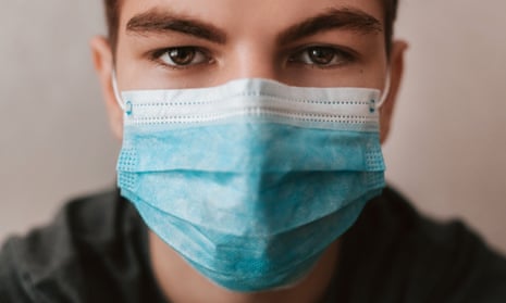 A young man wearing a medical mask (posed by a model)