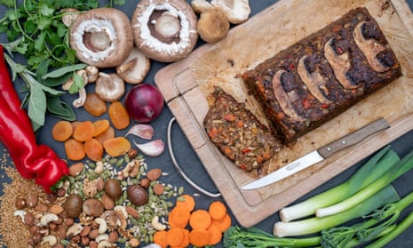 A vegan nut roast on a platter, plus mushrooms, spring onions and carrots