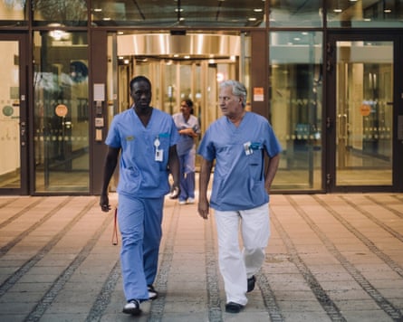 Doctors in scrubs talking while leaving hospital at night