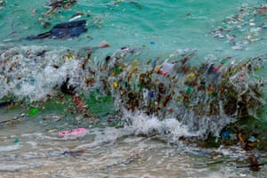 Koh Samui, Thailand: a wave carrying plastic waste and other rubbish breaks on a beach