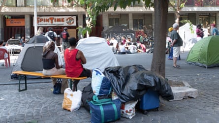 Young people carrying suitcases and belongings in Rome urban area.
