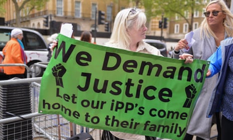 A woman holds a sign at a protest calling for offenders jailed under IPP sentences to be allowed to come home.