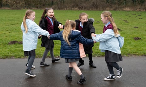 A group of children play outdoors at a school in Cardiff, Wales.