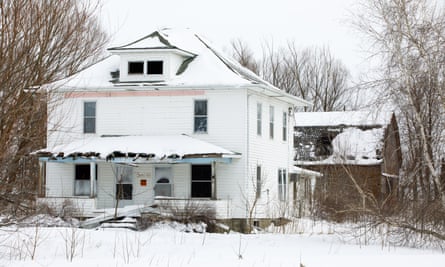 An abandoned farm house with graffiti on the front