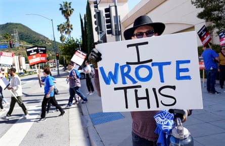 Justice Hardy, a writer on the television series True Lies, holds up a sign as members of the Writers Guild of America picket outside Warner Bros Studios.