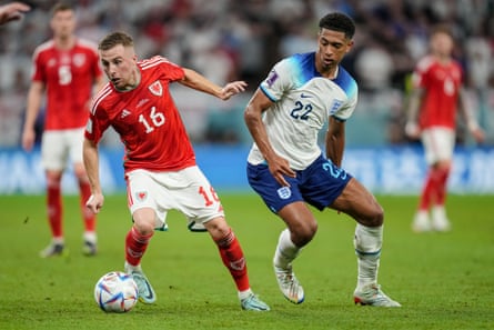 Joe Morrell tries to accelerate away from Jude Bellingham during Wales’s game against England at the 2022 World Cup.