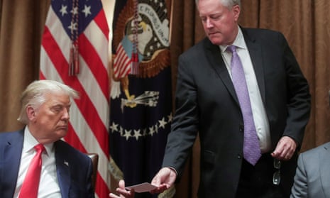 The then White House chief of staff, Mark Meadows, passes a note to Donald Trump in the cabinet room of the White House on 3 August 2020.