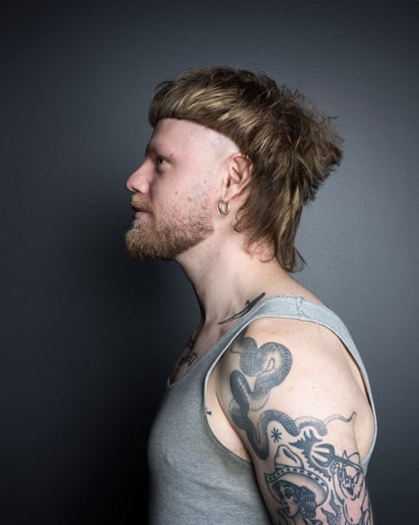 Man with red hair styled in faded mullet with red beard