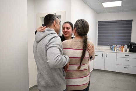 O soldado israelense liberado Karina Ariev, que foi mantido em cativeiro pelo Hamas, abraça os entes queridos depois de ser libertado, em um local desconhecido, no sábado.