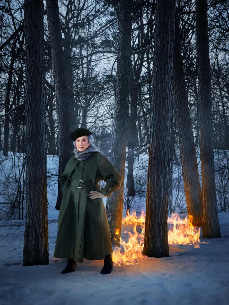 Margaret Atwood standing in a snowy wood with a trail of fire behind her