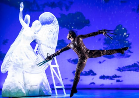 رقصنده با قیچی برای دست در مقابل یک مجسمه یخی بزرگ از یک زن