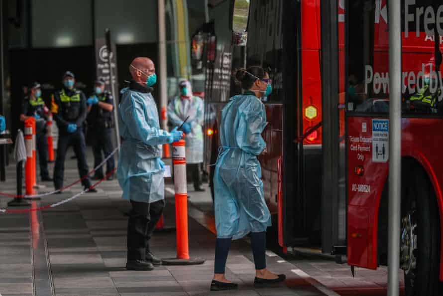 Hotel quarentine workers are seen in full PPE gear as they ask recently arrived international travellers to get off the bus and enter hotel quarantine in Melbourne.