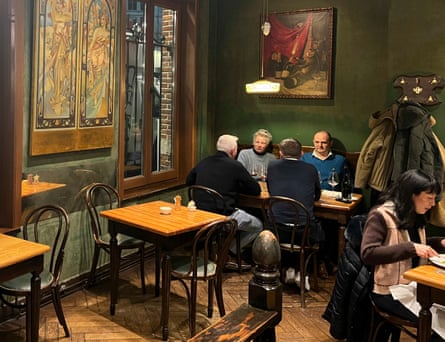 Dining room with dark green walls and paintings at Les Brigittines.