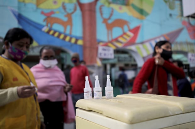 Health workers wait with a polio vaccination box at a railway station in Kolkata, India.