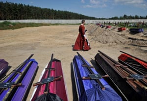 An Orthodox priest serves during the funeral ceremony of twenty unidentified people killed in February and March at the cemetery in Bucha
