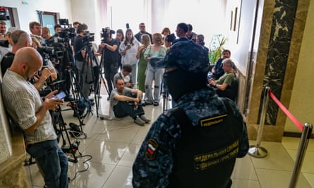 Crowds of press people and a Russian guard