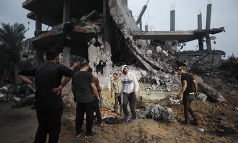 Palestinians search for bodies and survivors among the rubble of a destroyed house following Israeli airstrikes on Deir al-Balah.