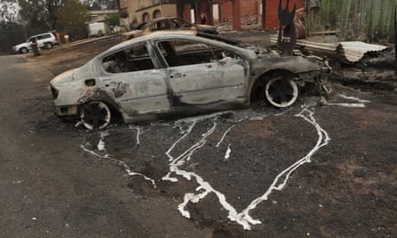 A burned out car outside a house in Conjola Park, New South Wales.