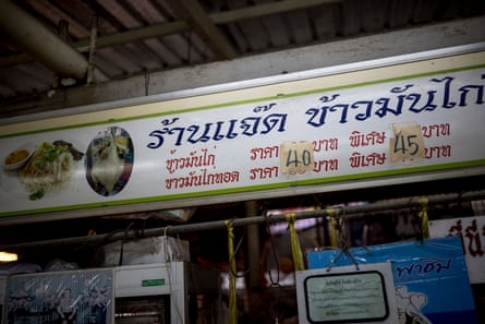 Los precios aumentados de las harinas de pollo y arroz se muestran en pegatinas en un puesto de comida en Bangkok, Tailandia.