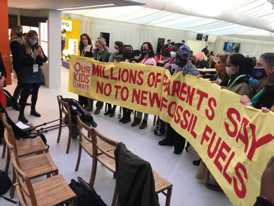 Parents carrying banner reading: 'Millions of parents say no to new fossil fuels'