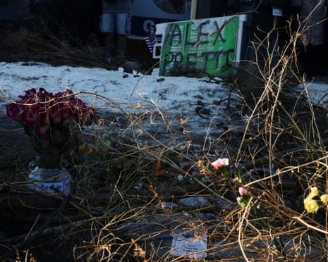 People leave signs, flowers and candles at a site where Alex Pretti was fatally shot in Minneapolis, Minnesota.