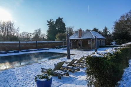 A snow-covered swimming pool and clubhouse.