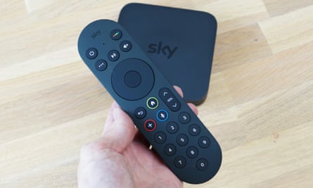 Sky streaming box and remote control on wooden table.