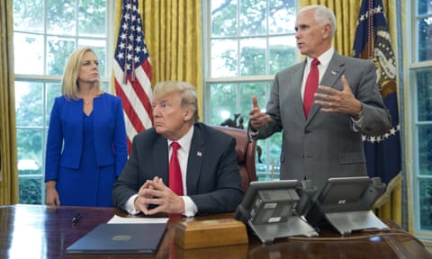 Donald Trump and homeland secretary Kirstjen Nielsen listen to Mike Pence before signing the executive order