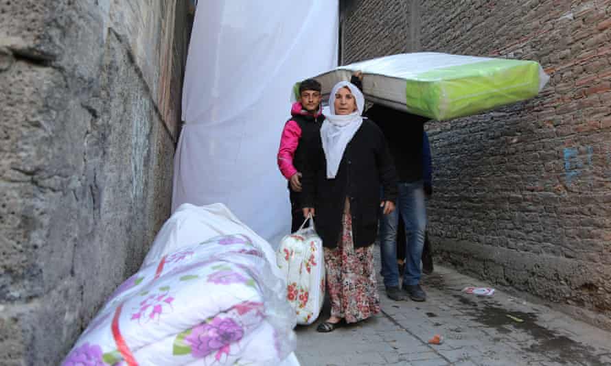 Kurdish residents flee with some of their belongings after new curfews were imposed in the Sur district of Diyarbakir
