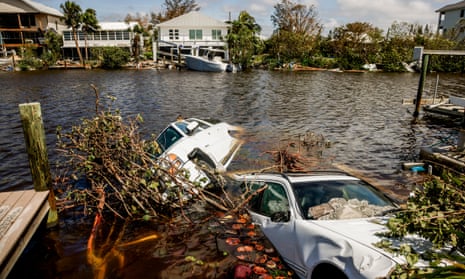 Vehicles are submerged in a canal in the wake of Hurricane Ian in Bonita Shores, Florida, on Thursday.