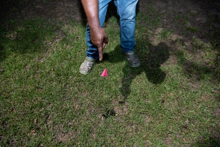 a man points to a flag marker in the grass