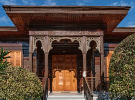 Two cats rest in the gentle afternoon light on the steps of a historic wooden house in Büyükada, Istanbul.