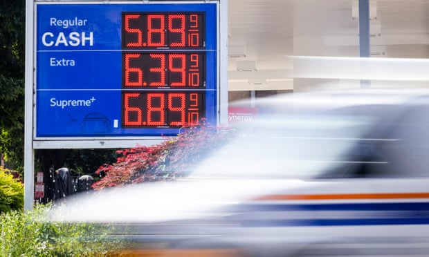 A car drives by an Exxon gas station displaying its prices in Washington DC.