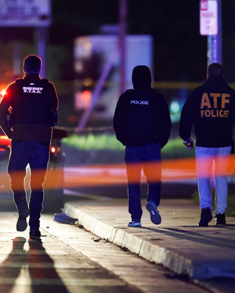 three police officers walk along a street