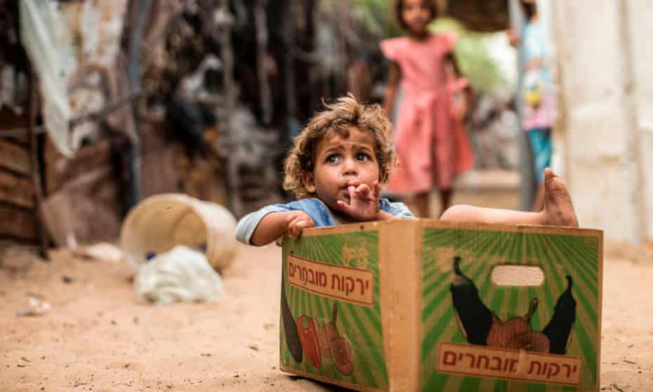 A Palestinian toddler sits inside a cardboard fruit box in Gaza City on August 8, 2017.