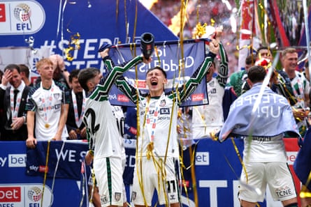 Sunderland’s Chris Rigg has champagne poured on him after the 2025 playoff final