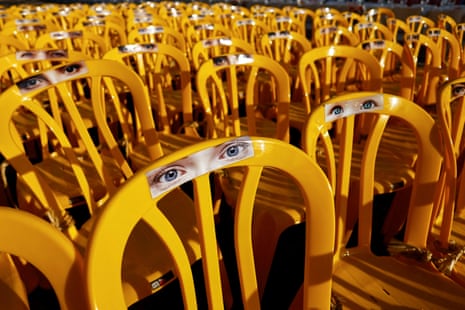 Pictures of eyes are stuck onto empty chairs symbolically representing Israeli hostages, who are being held in the Gaza Strip