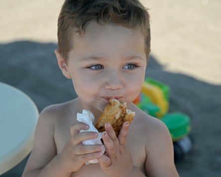 A child eating something on the beach