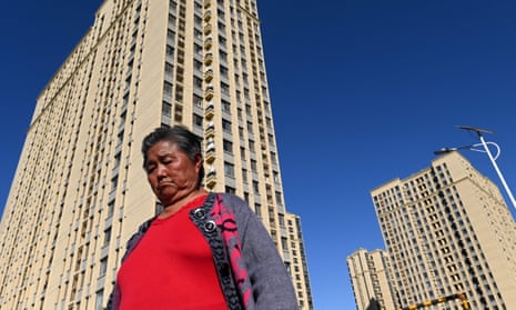 A woman walks in front of a housing complex by Chinese property developer Evergrande in Beijing 