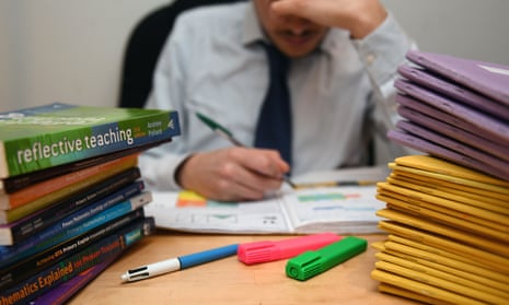 a teacher next to a pile of classroom books