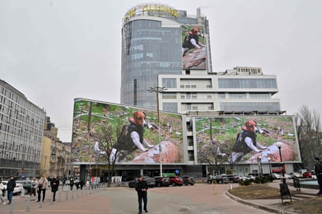 A photo of Patron, an army bomb detection dog and mascot for the State Emergency Service of Ukraine, is displayed on screens at a Kyiv mall.